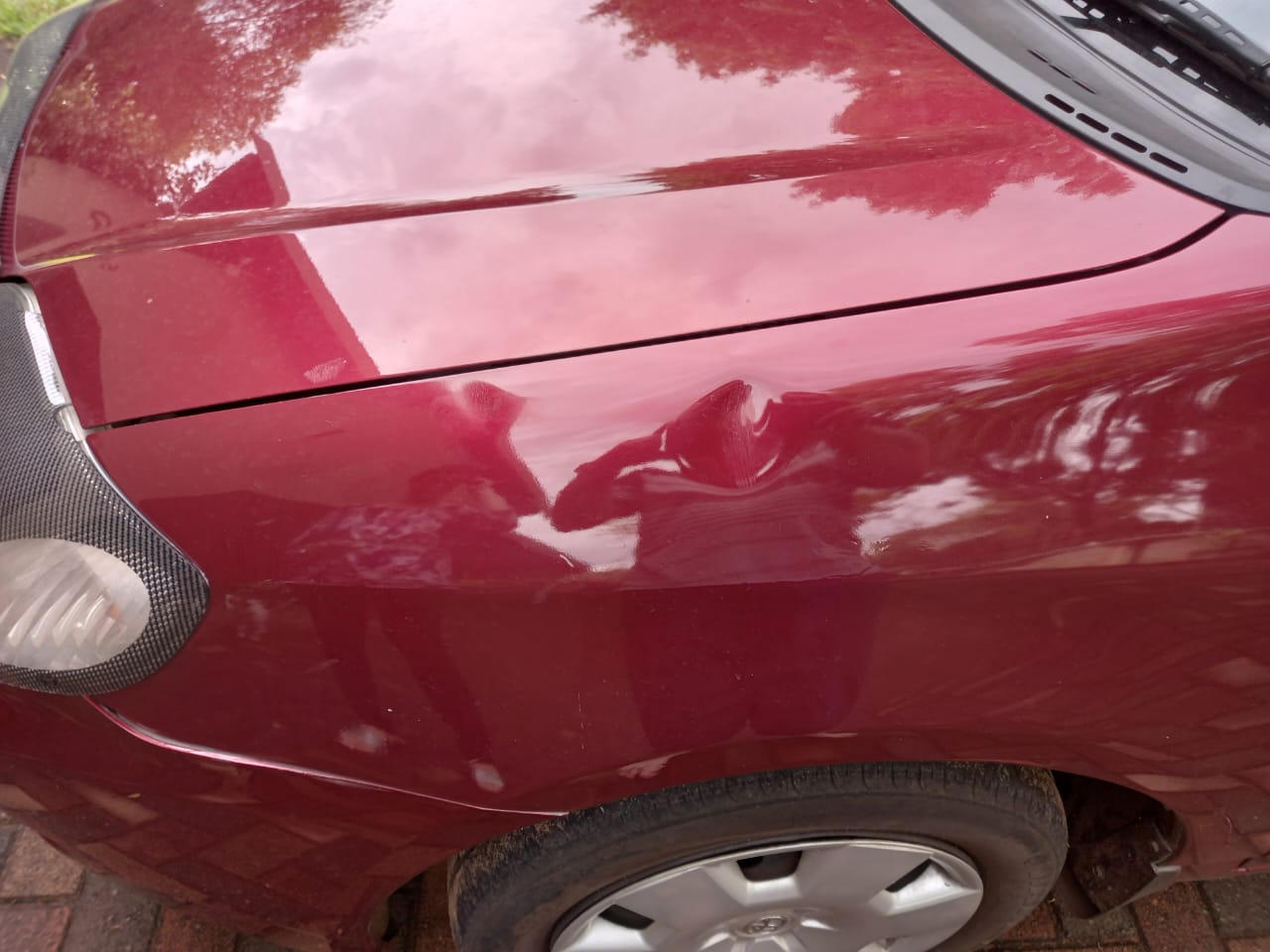 Big dent on the fender of a Toyota Corolla